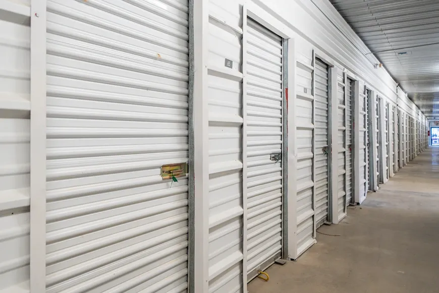 Indoor storage hallway with white roll-up unit doors and secure access